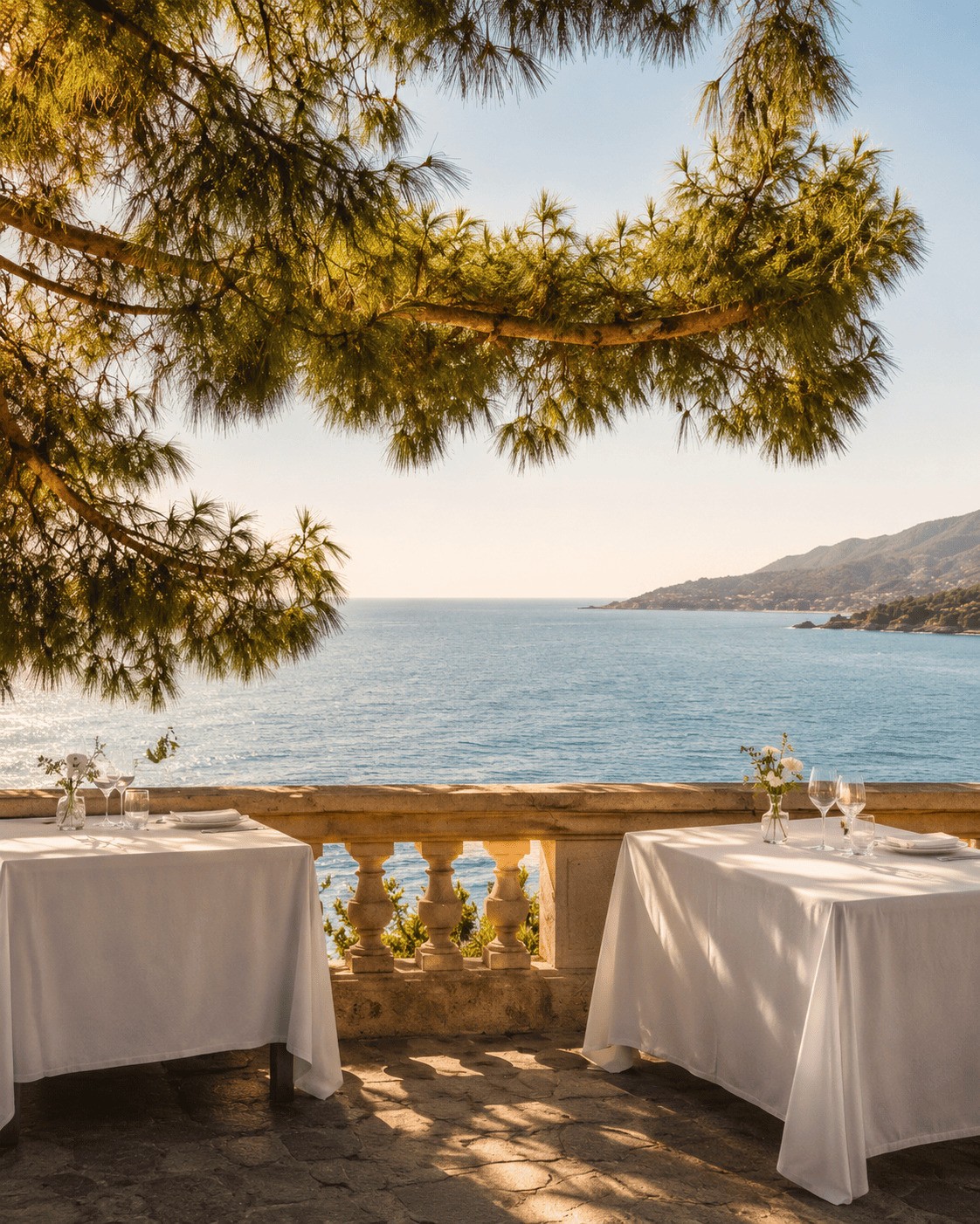 Luxury seaside dining terrace framed by pine trees with scenic ocean views near Barcelona, representing high-end coastal living and amenities in Maresme.