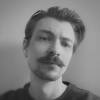 man standing near white wall