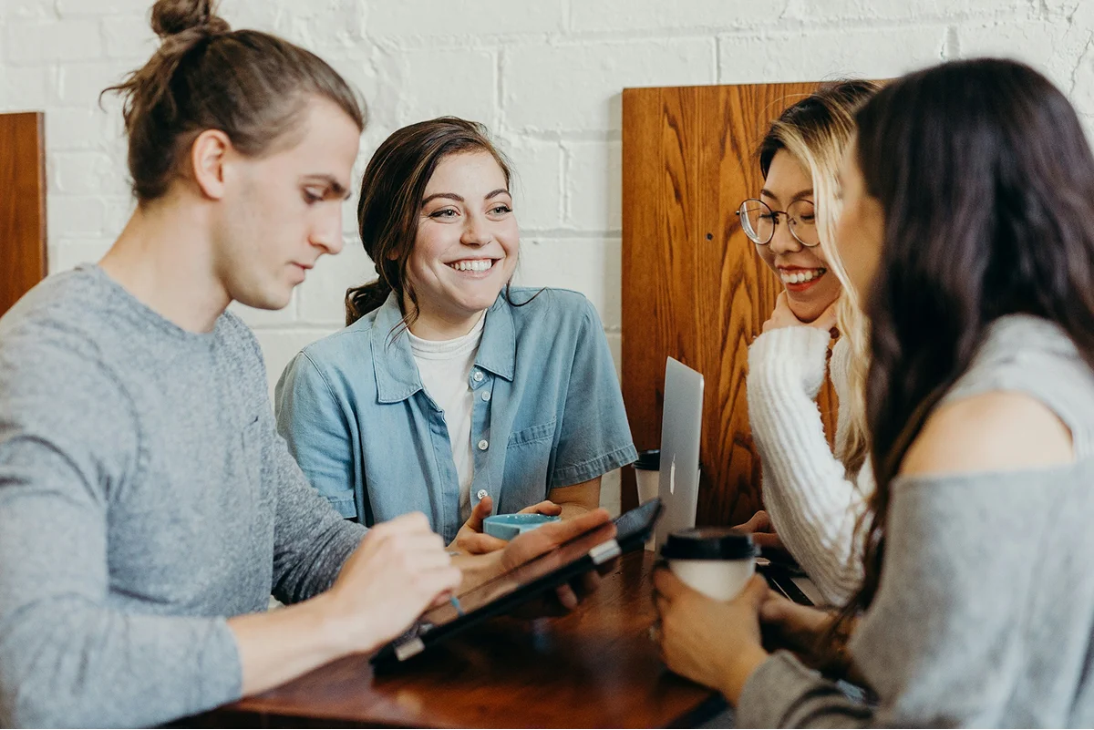 Four people chatting around a cafe table.