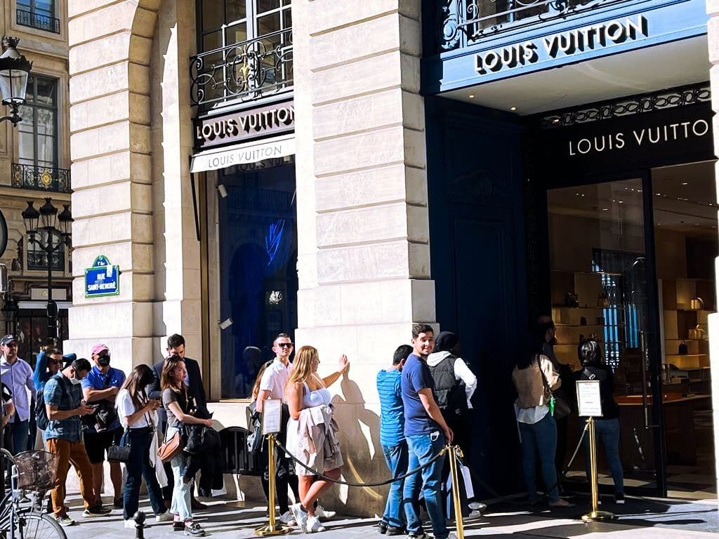 People waiting in line outside a Louis Vuitton store