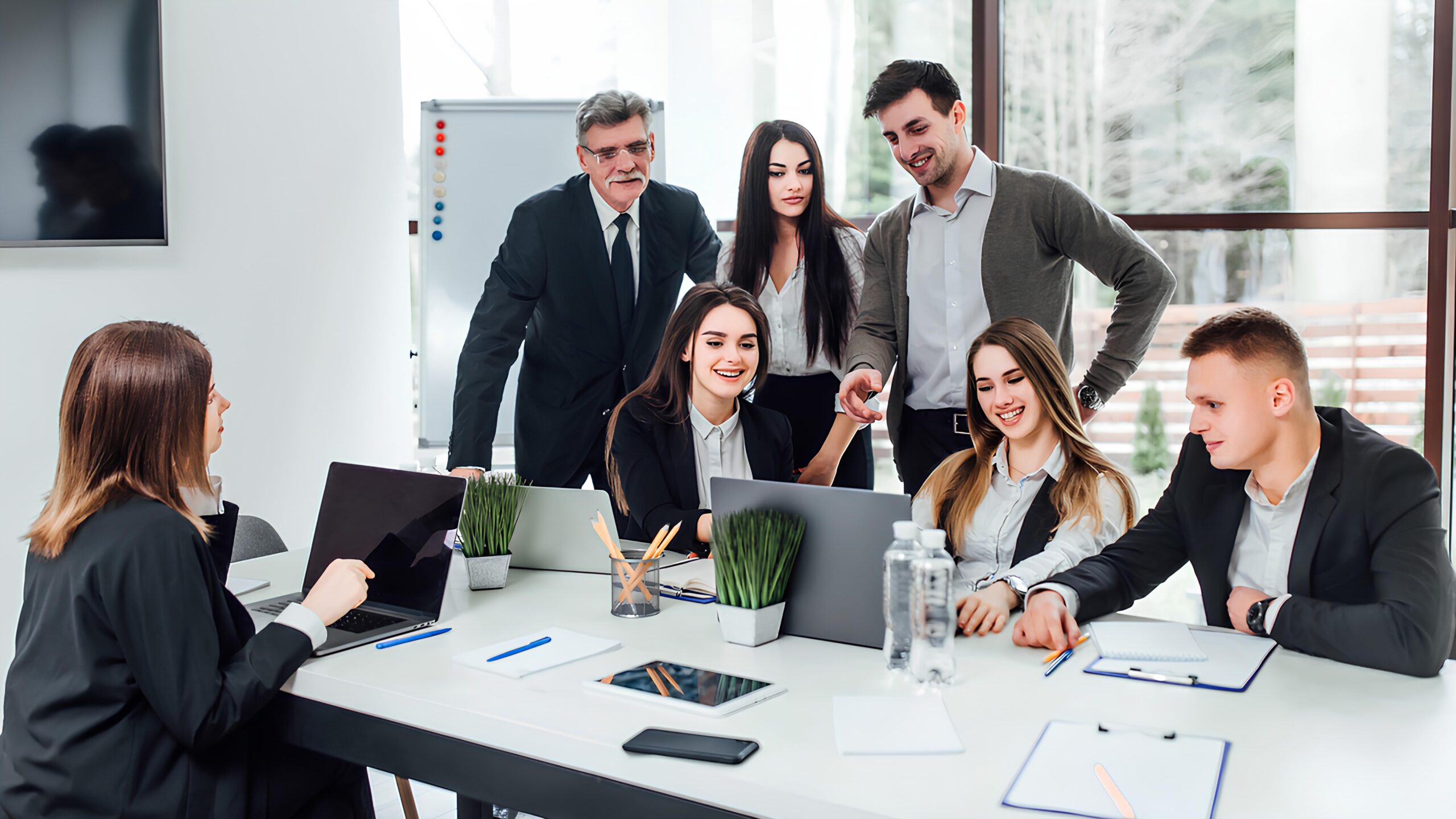 Team collaborating around laptops in a modern office