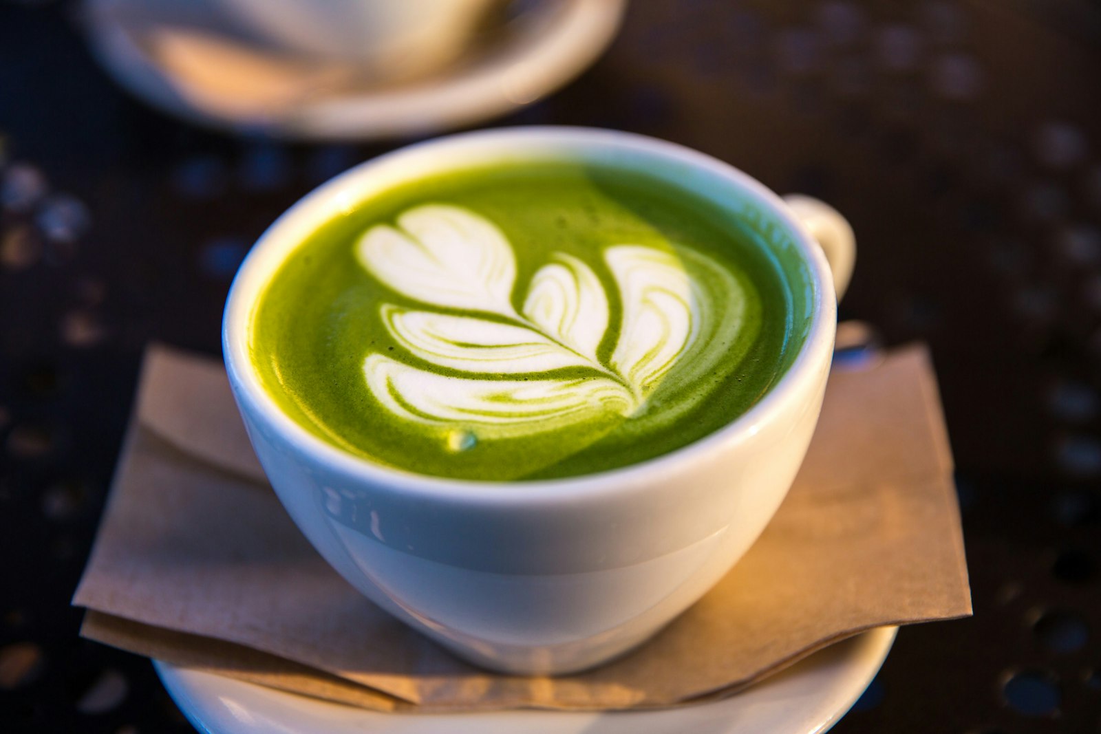 Taza blanca de matcha en cerámica sobre una mesa con fondo oscuro