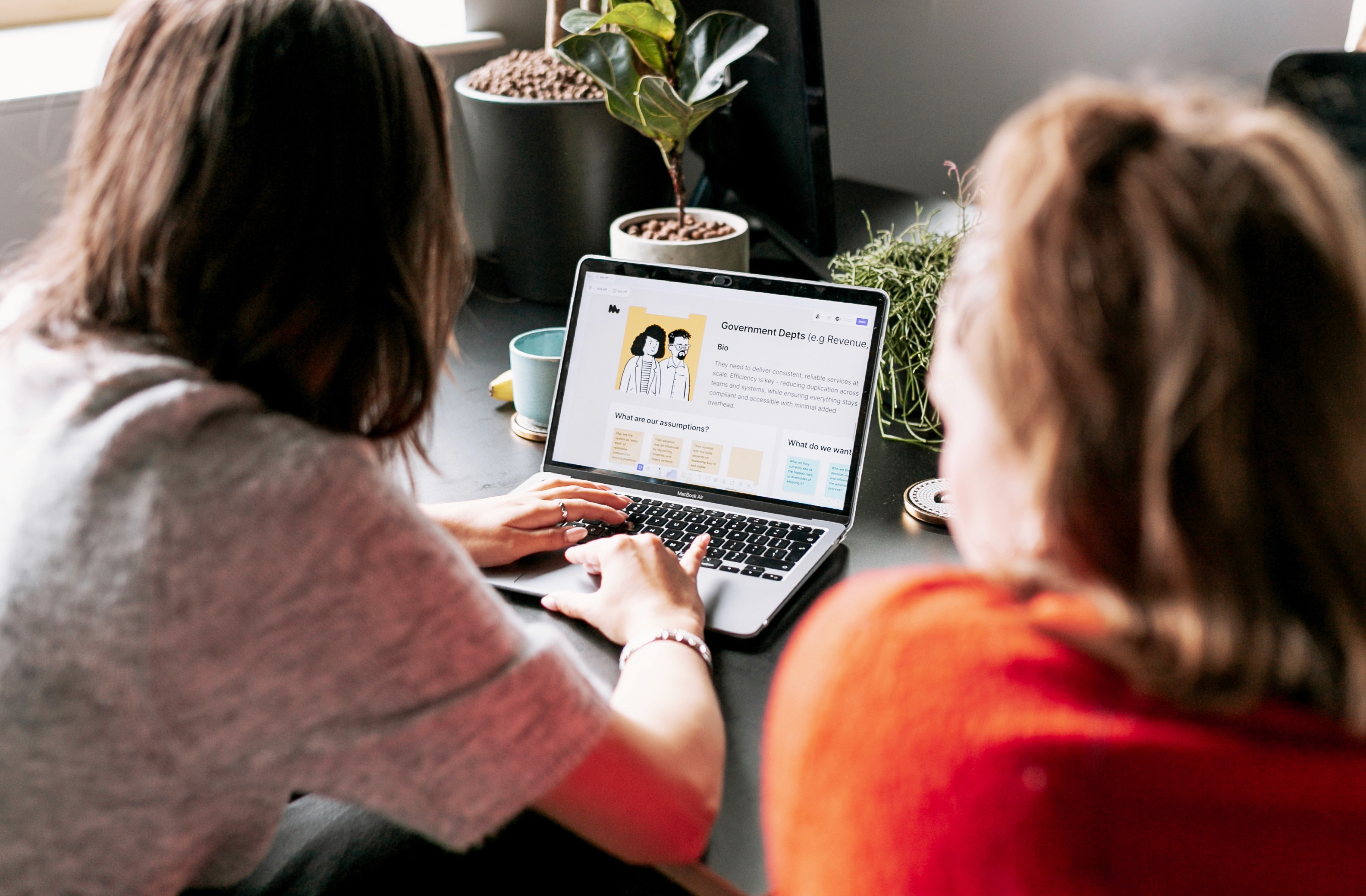 Two team members reviewing a project on a laptop during a working session