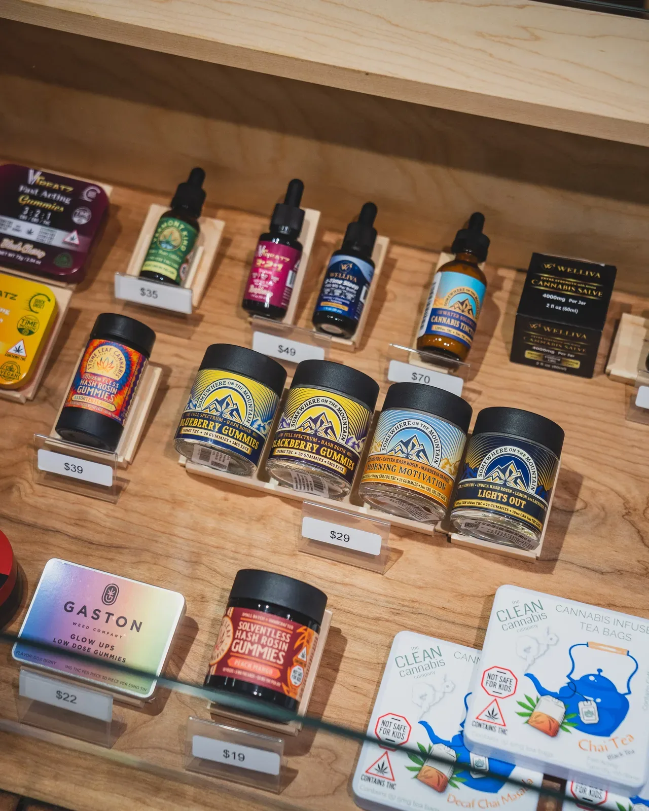 Cannabis edibles display at a Vermont dispensary including tinctures, gummies, and infused tea bags with price tags