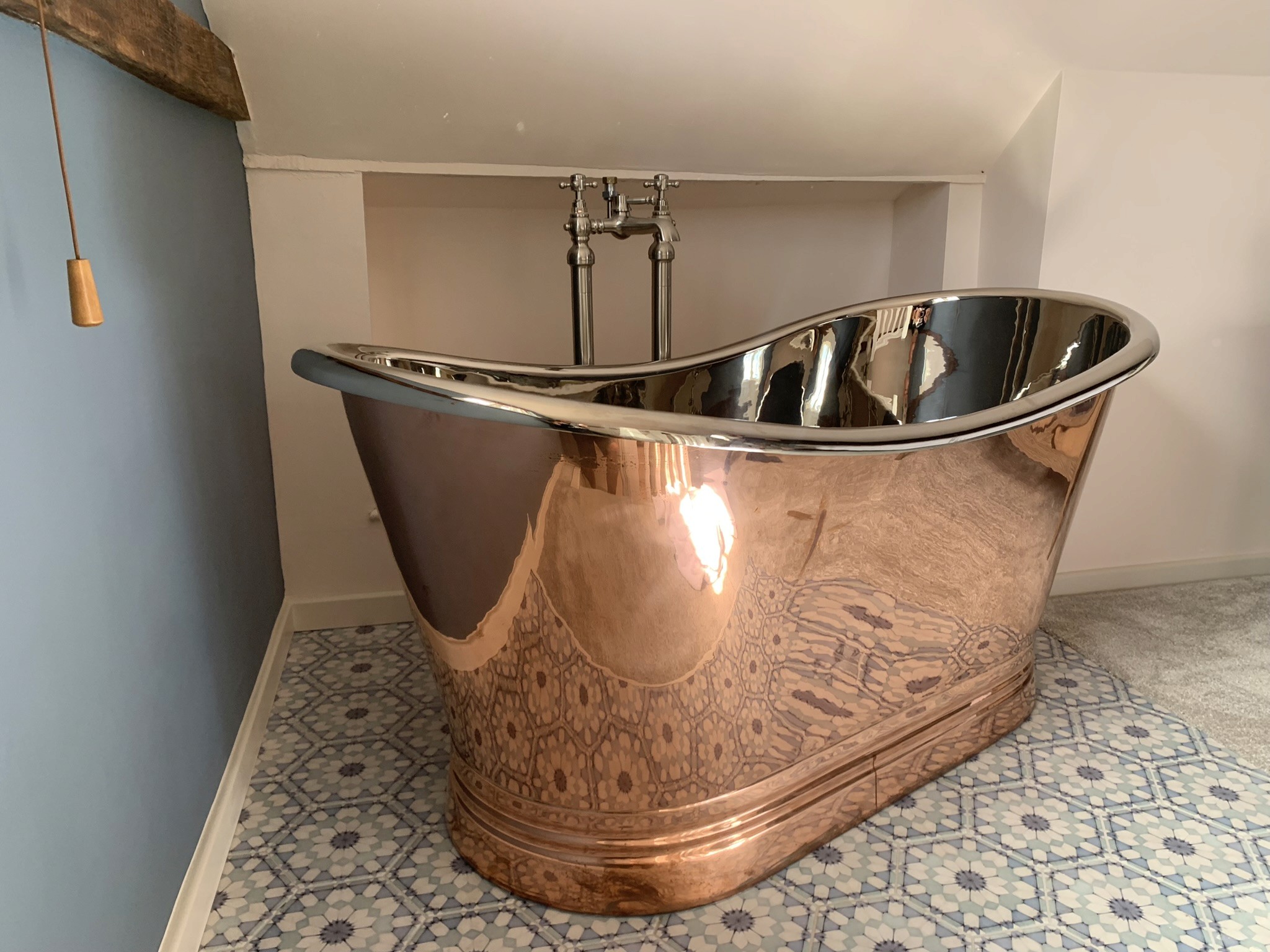 Luxury copper bath in tiled bathroom