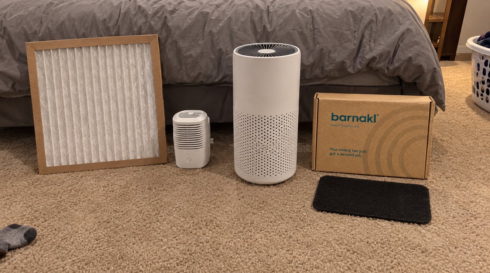 The four air cleaners tested, lined up on a bedroom floor: a furnace filter, a small plug-in purifier, a HEPA tower and a Barnakl Pearl kit.