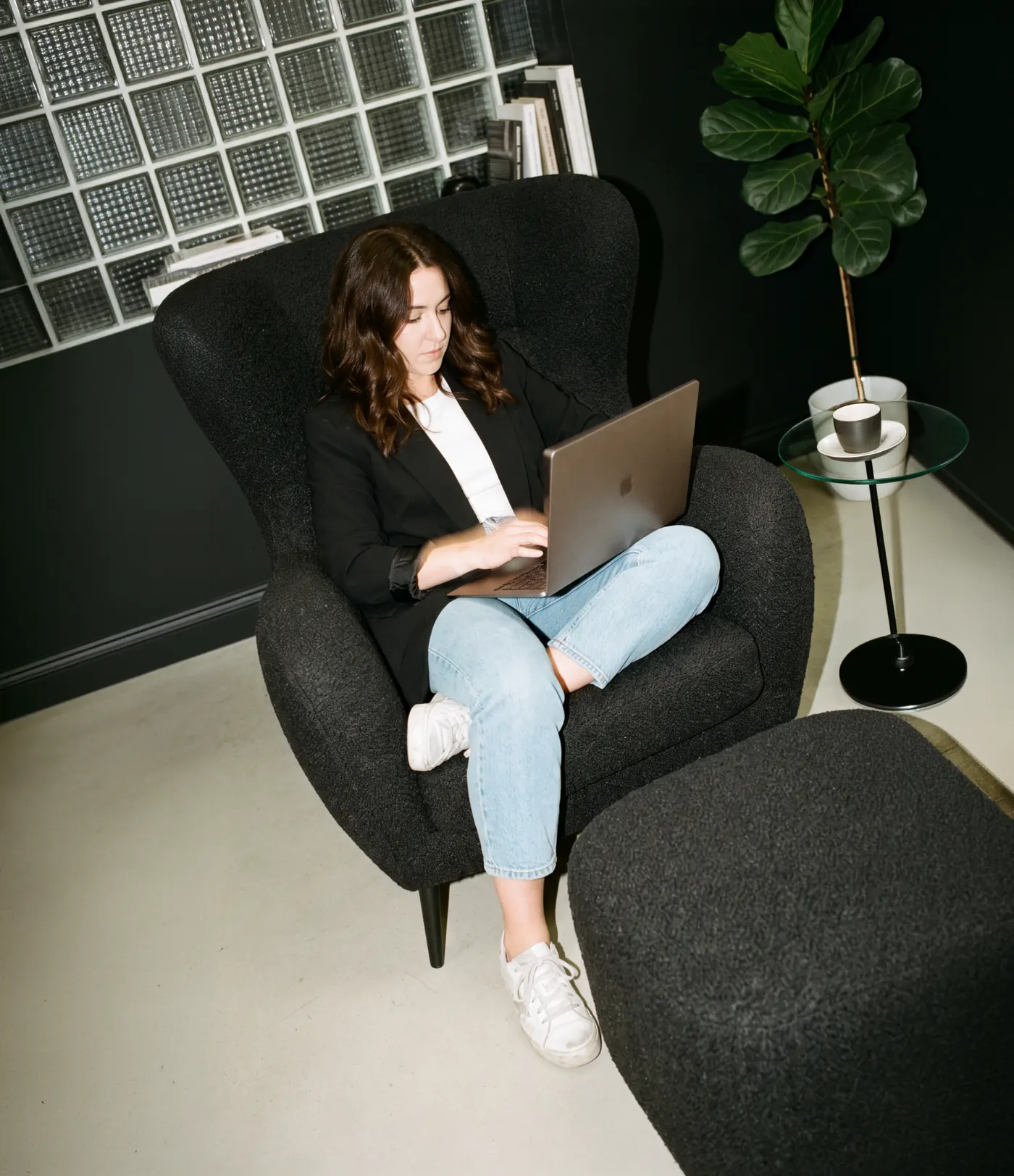 A Flexiti team member working on a laptop in a lounge chair