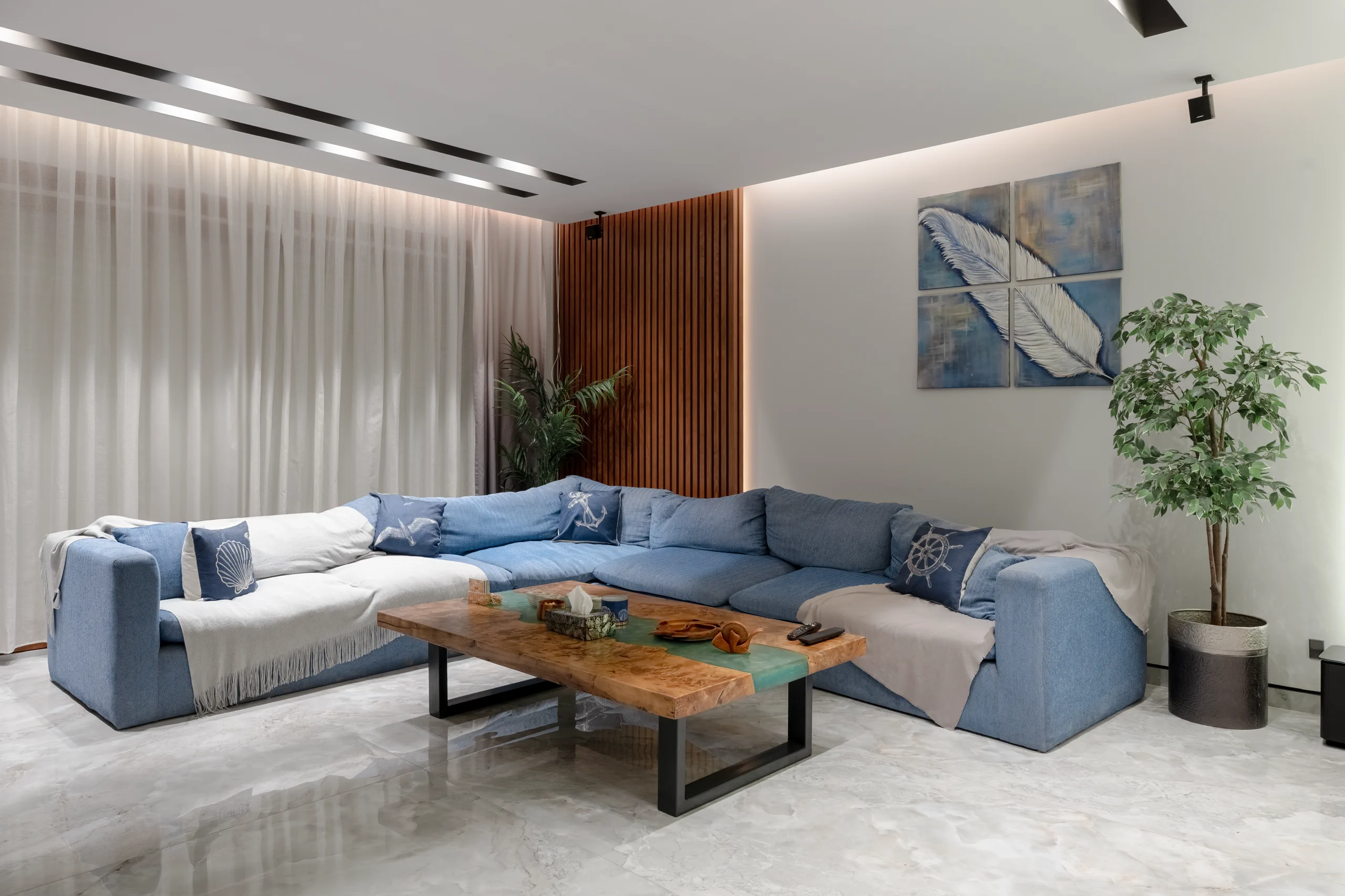 Family living area at Caesar SODIC Villa with custom blue seating and a natural wood coffee table.