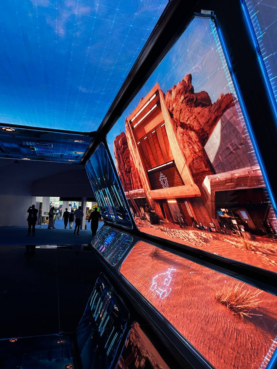 A large group photo of diverse team members gathered in an industrial-style space with arched ceiling.
