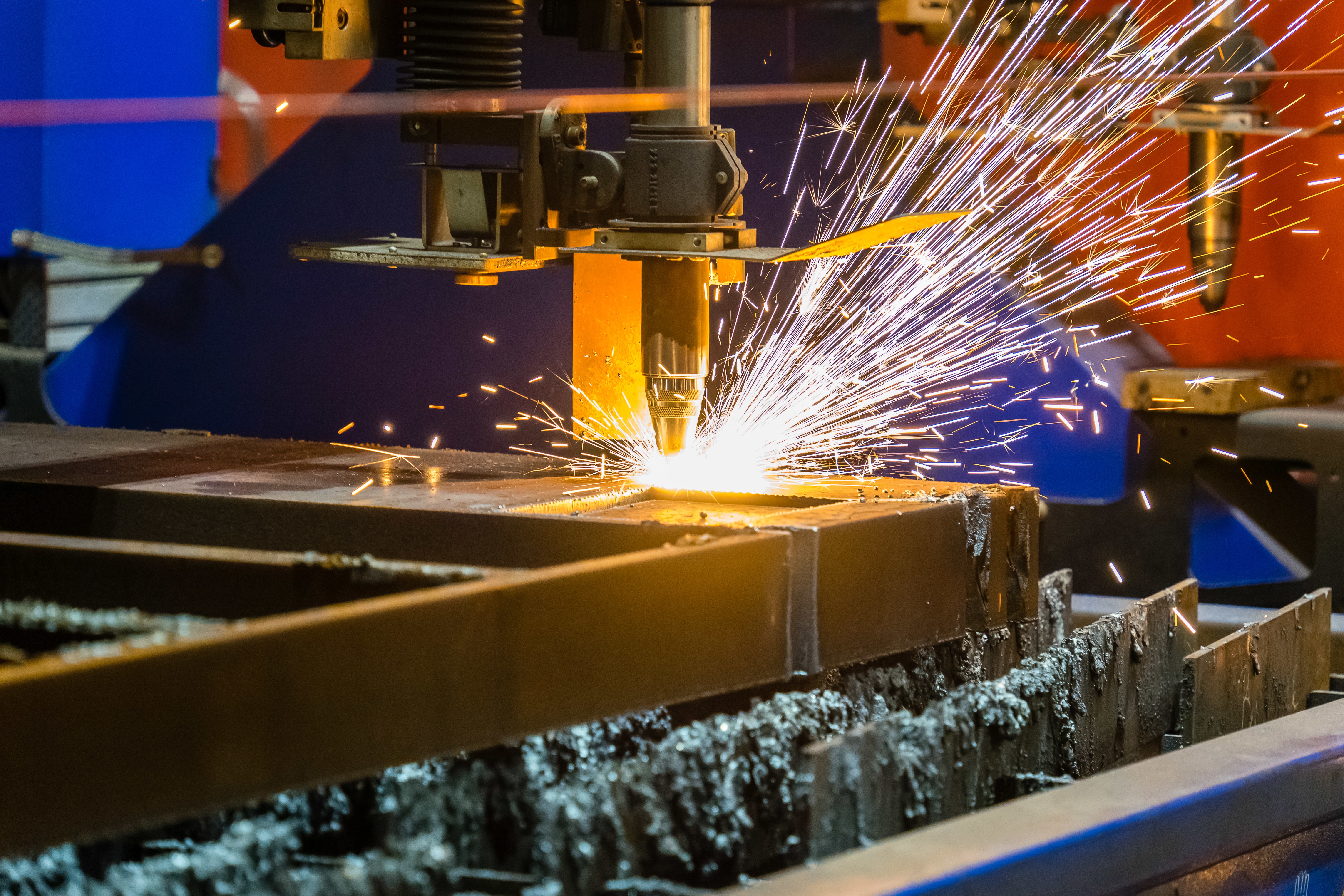 A CNC machine cutting metal, emitting bright sparks. The atmosphere is industrial, with vivid orange and blue tones, conveying precision and energy.
