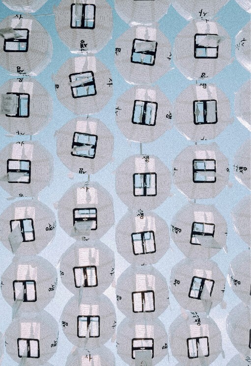 Many white paper lanterns hanging against a blue sky