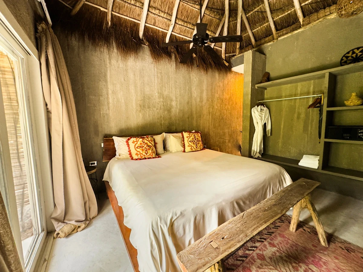 Standard Room at Nômade Tulum, featuring bed with pillows and closet.