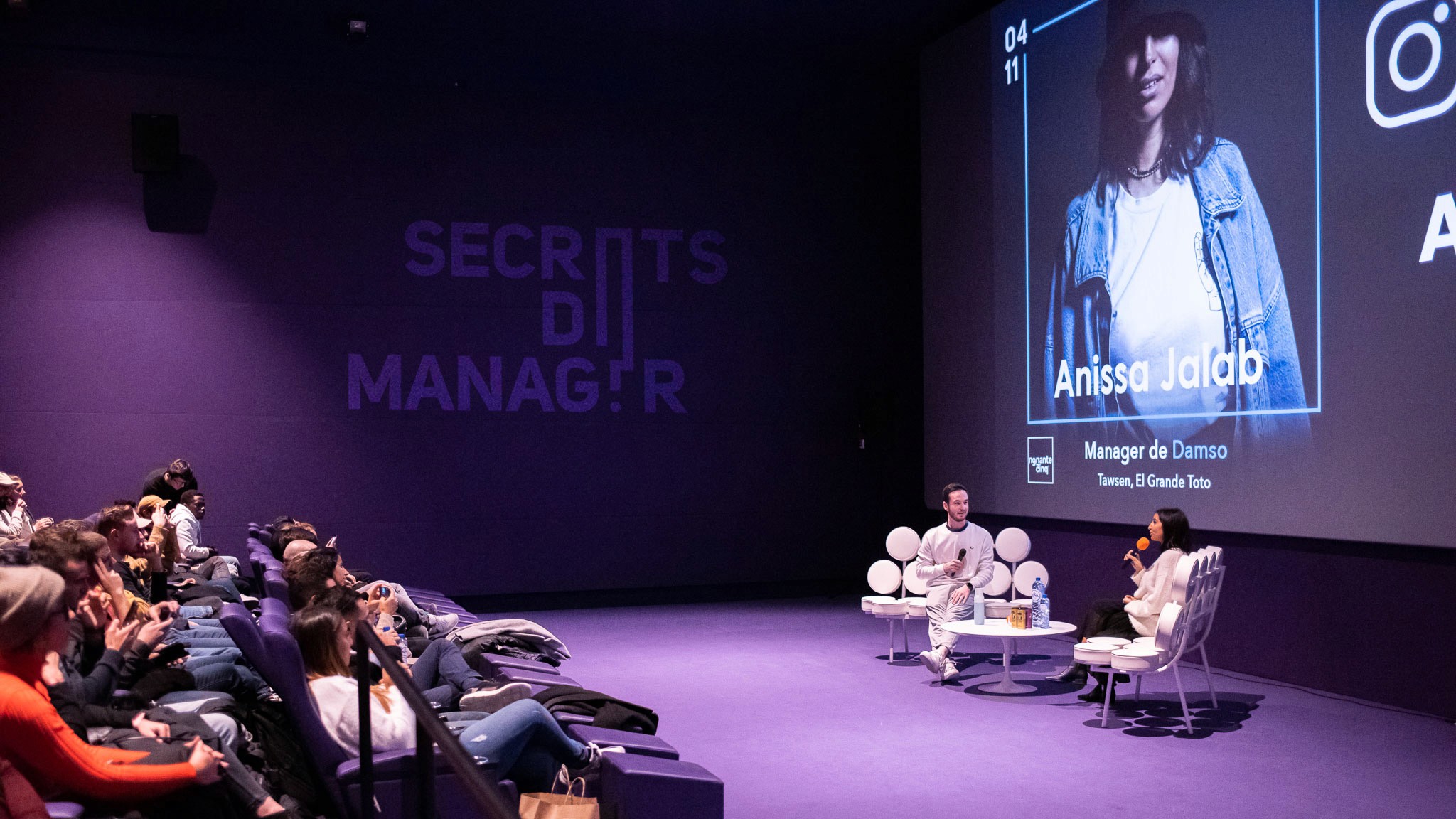 Modern home office setup with a monitor, ergonomic chair, keyboard, and indoor plants near a window with blinds.