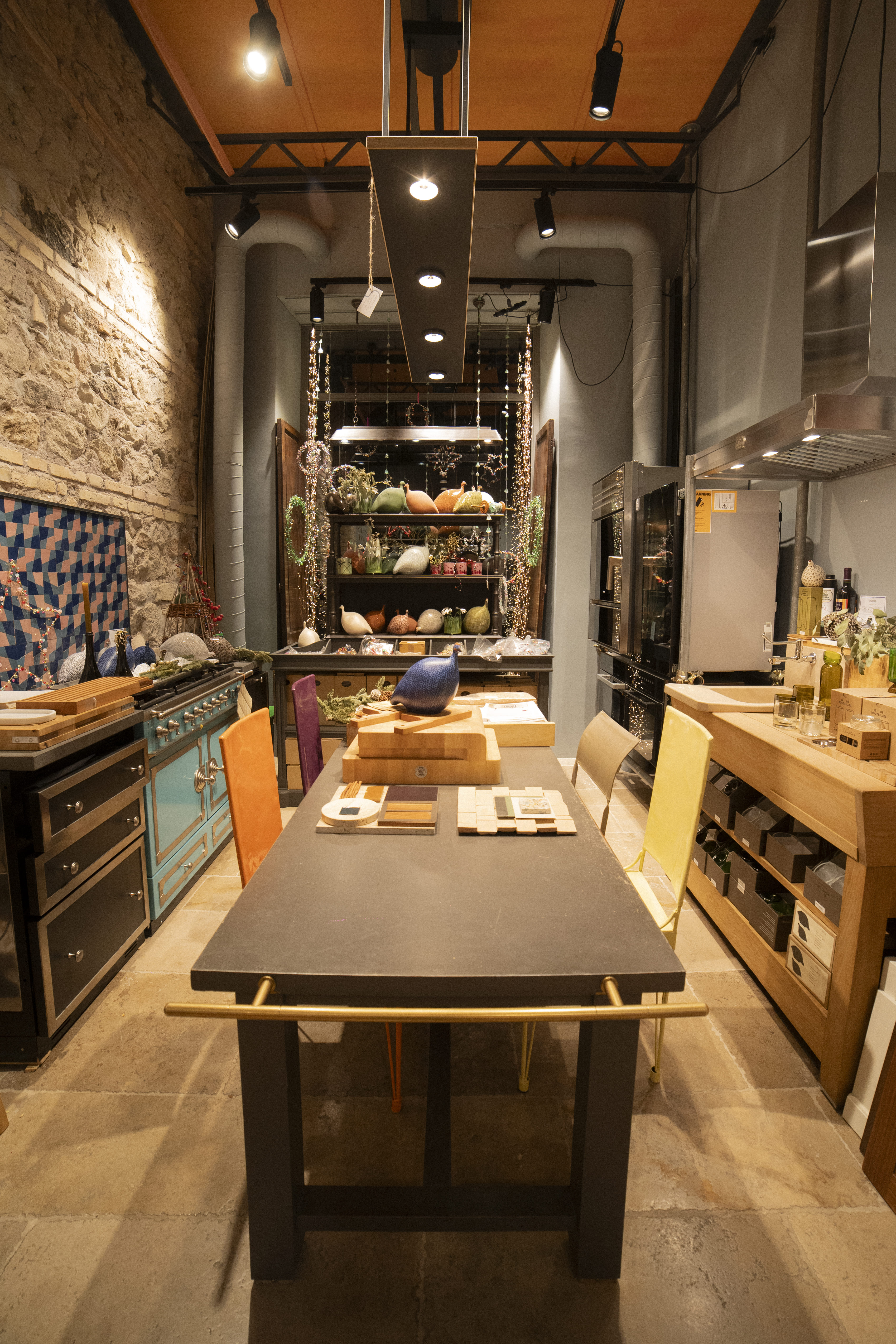 A scene of a table filled with swatch books overlooking a shelf filled with ceramic vases