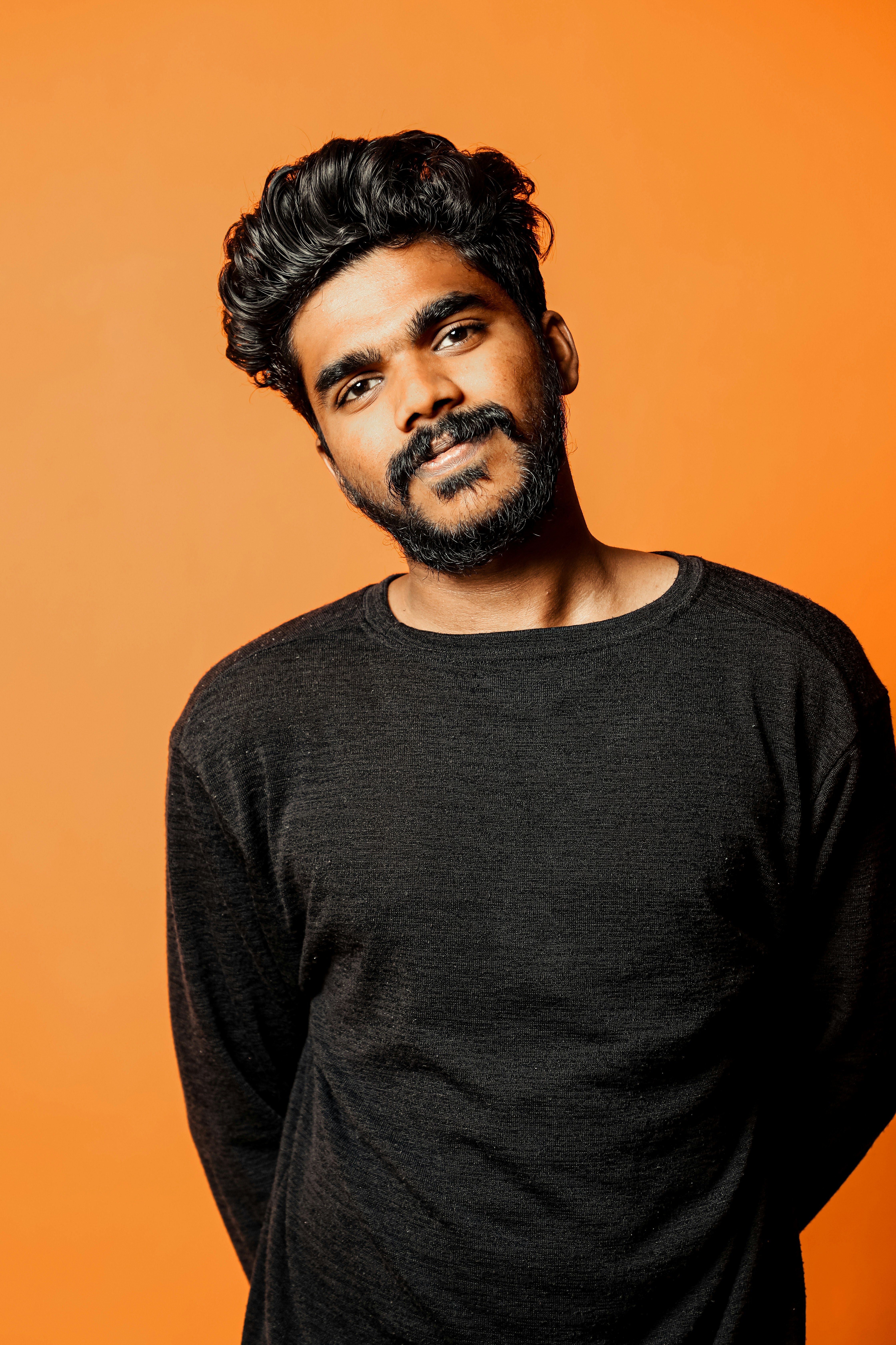 a man standing in front of an orange background