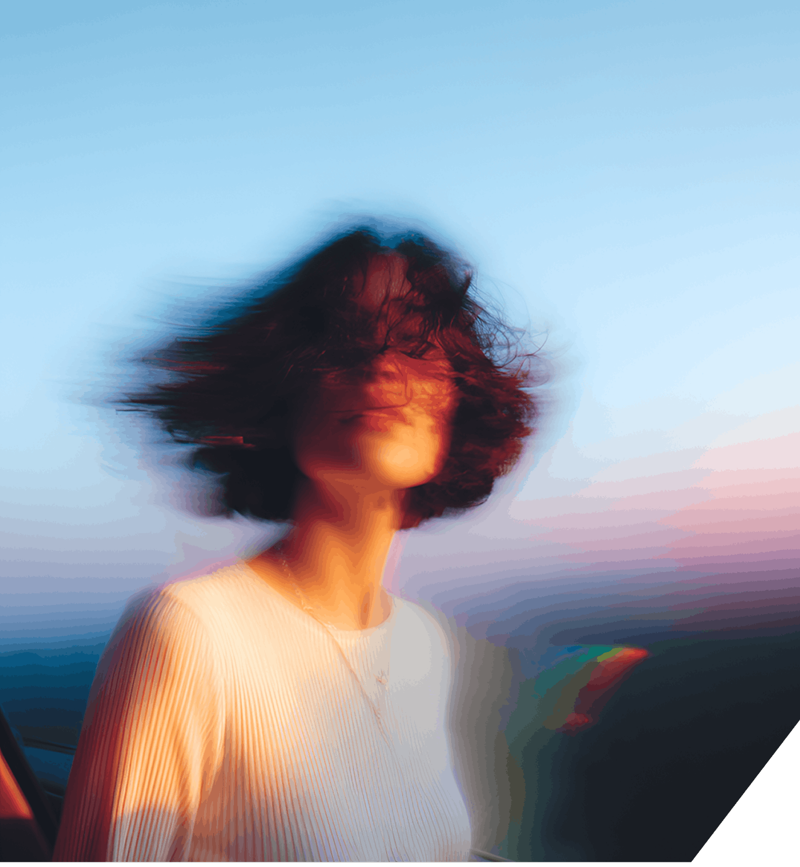A woman with her hair blowing in the wind, conveying a sense of vitality and connection to nature.