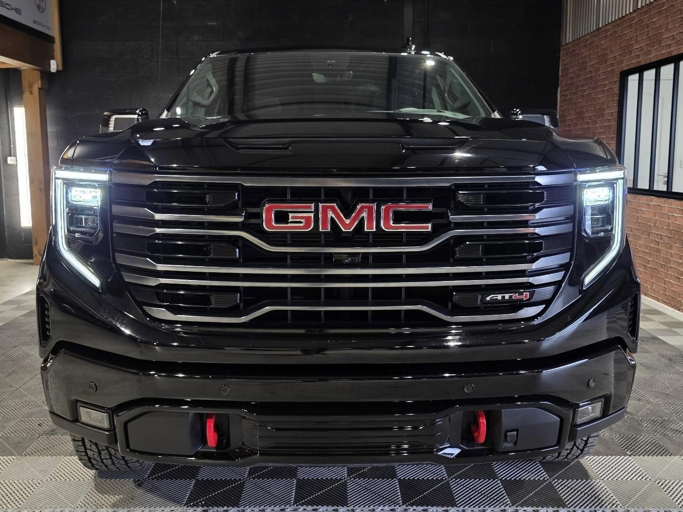 The image depicts a black, sleek, and modern-looking GMC vehicle with its headlights illuminated.
Le contenu généré par l’IA peut être incorrect.