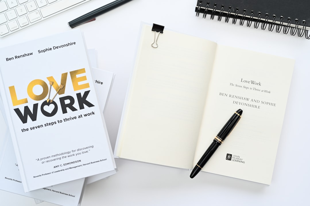 a notebook with a pen on top of it next to a keyboard