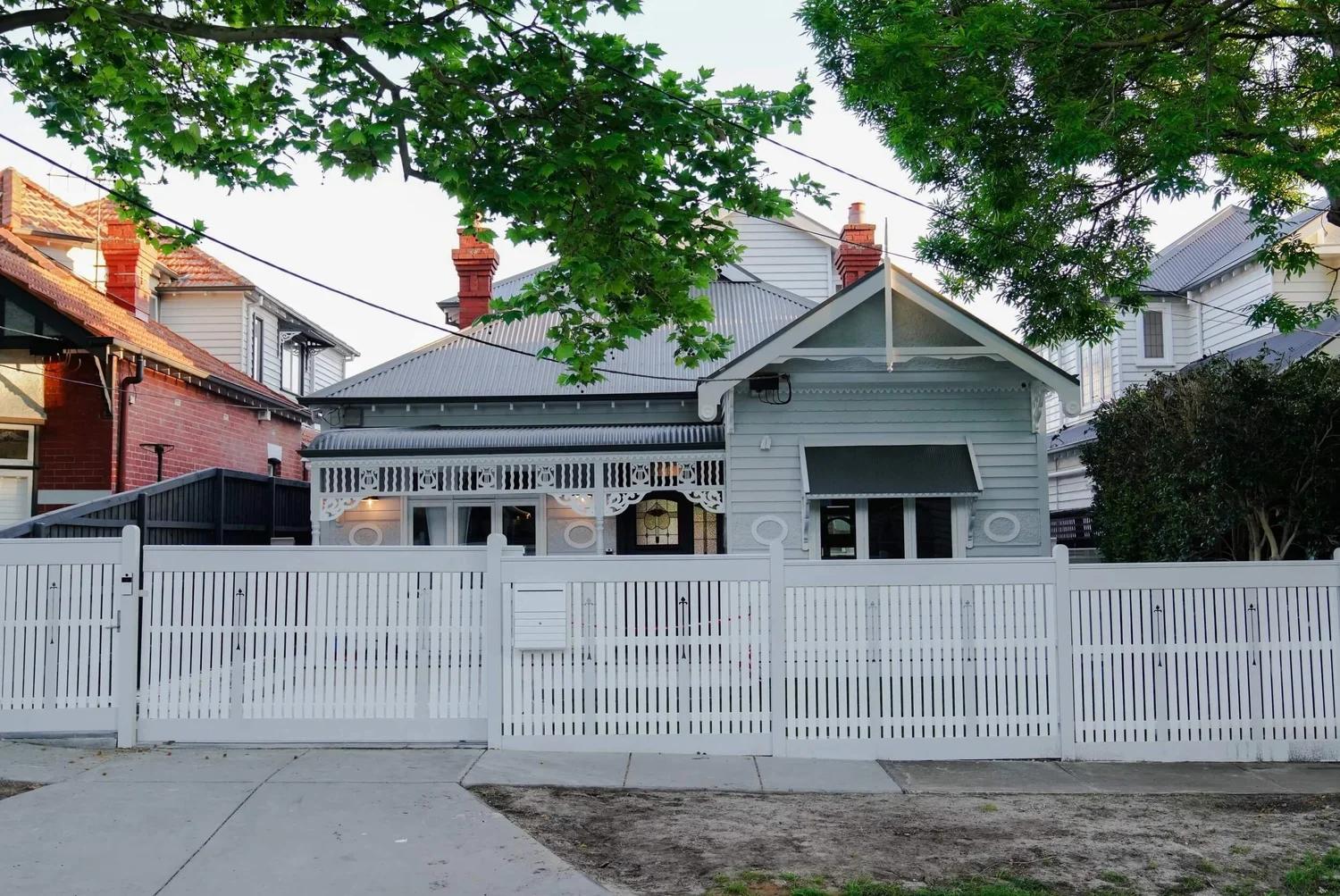 Charming Victorian house with white picket fence and ornate facade.