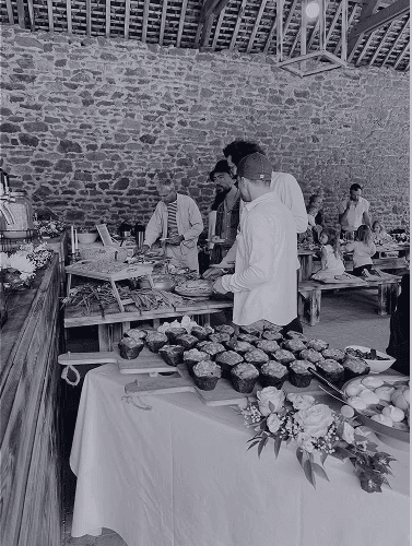A beautifully set dining table with white tablecloth, cutlery, and fresh greenery in a cozy, well-lit space.
