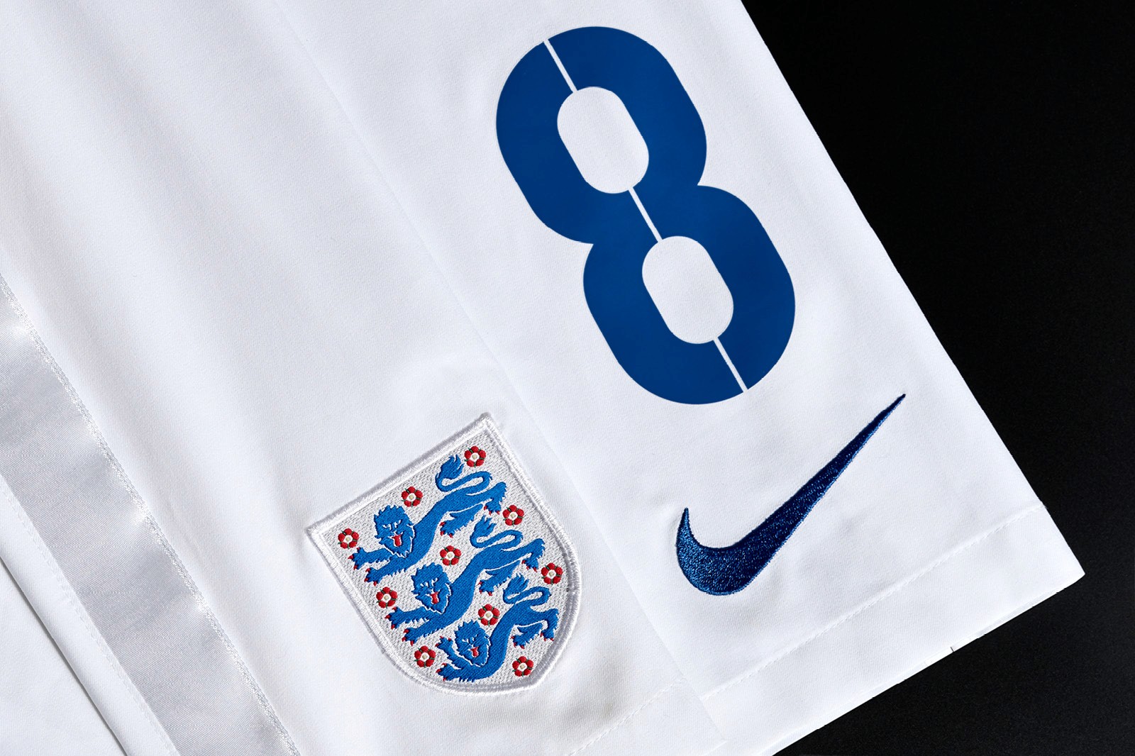 Close-up of a white sports jersey featuring the number 8 and the England football crest alongside the Nike logo.