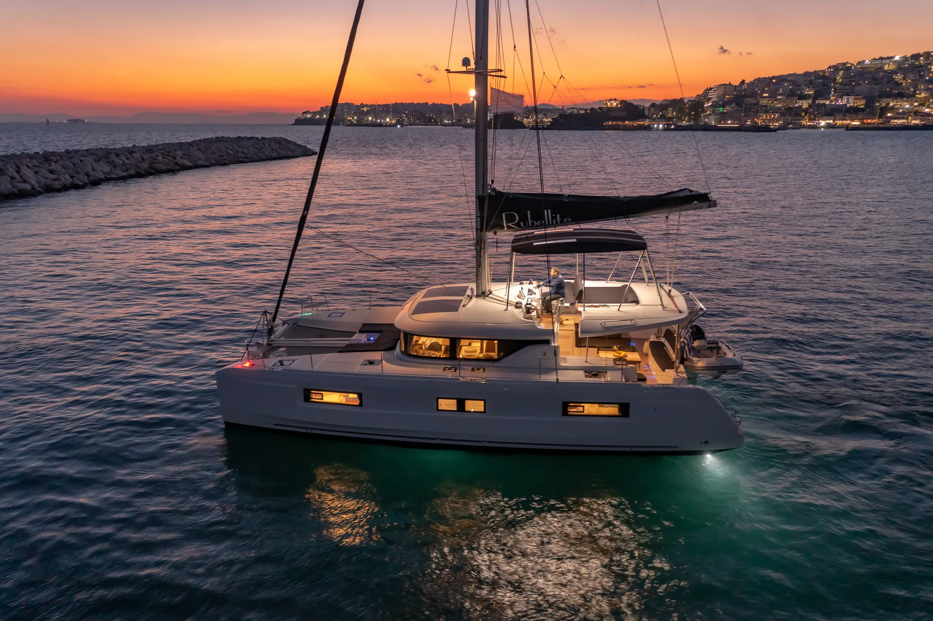 White Rock 36 speedboat with captain at helm cruising calm blue waters near Paros coastline with hills in background.
