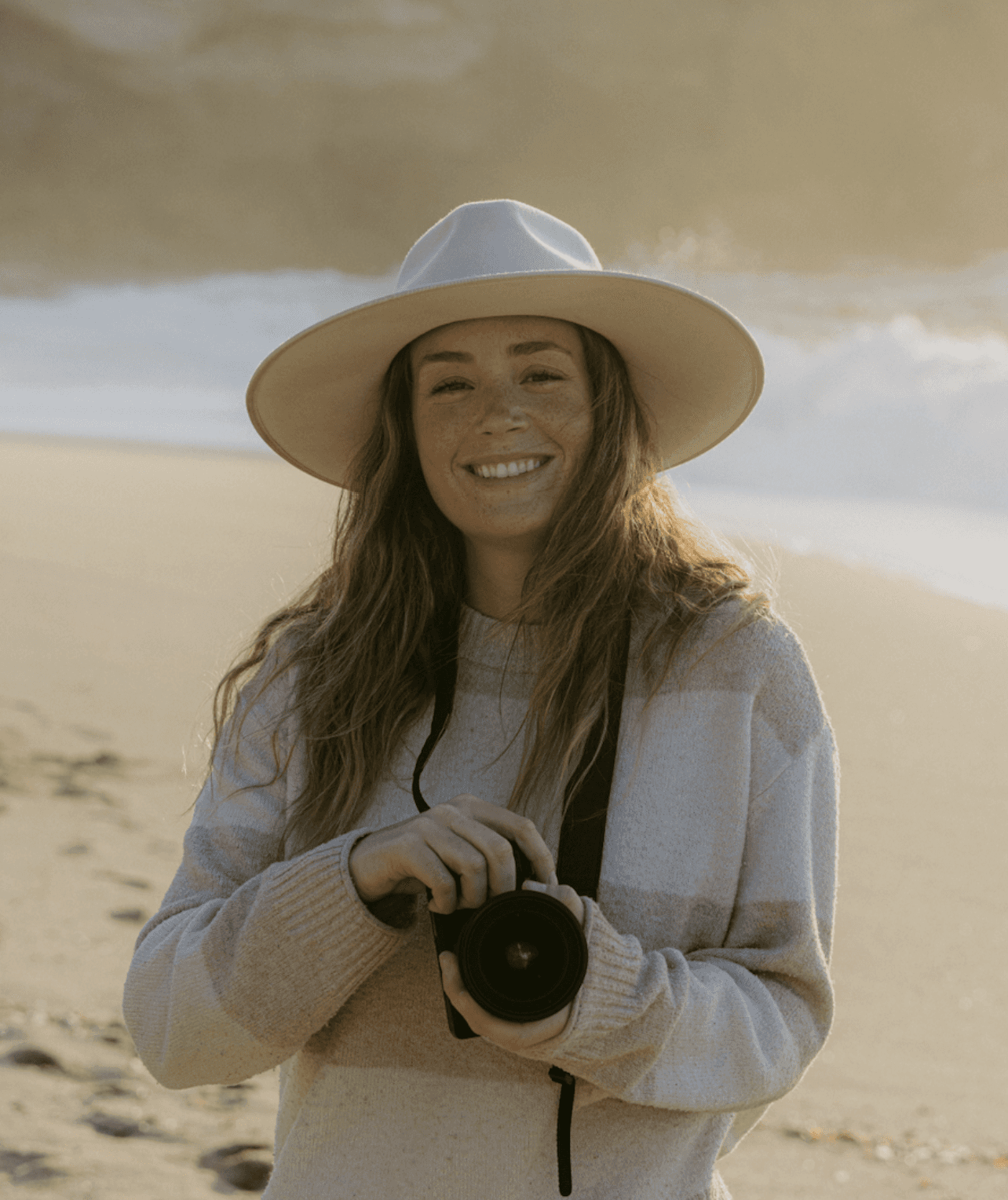 Personne tenant un appareil photo sur une plage