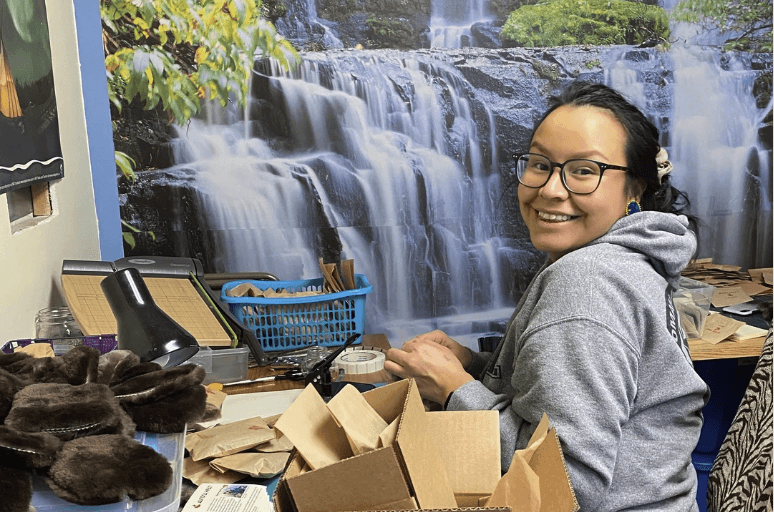 A person smiling beside packed boxes of Aurora Heat products