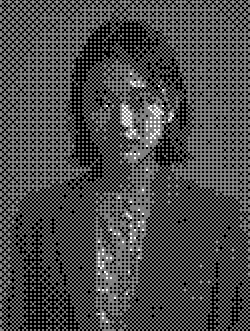 A portrait of a woman with long dark hair, wearing a dark blazer and a patterned shirt, looking serious.