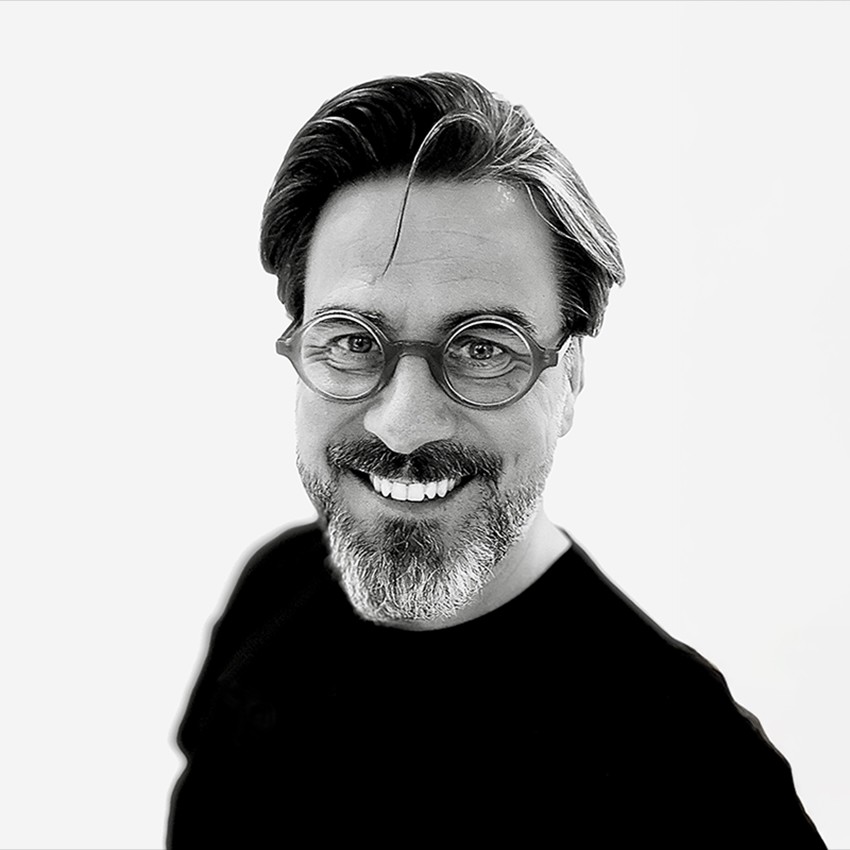 Black and white headshot of Dan Dimmock wearing a black t-shirt