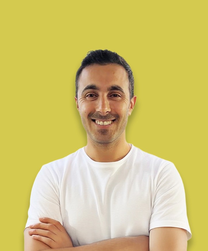 Portrait of a person in a pink sweater against a light background