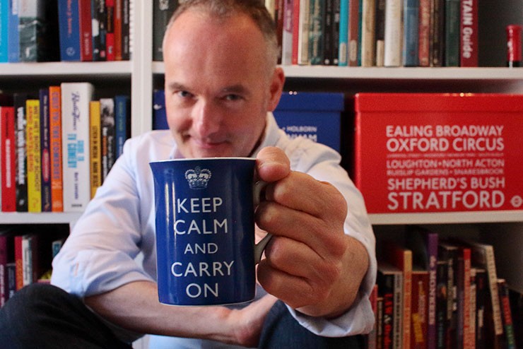 Patrick Bremmers met koffiebeker met de tekst daarop Keep Calm and Carry On