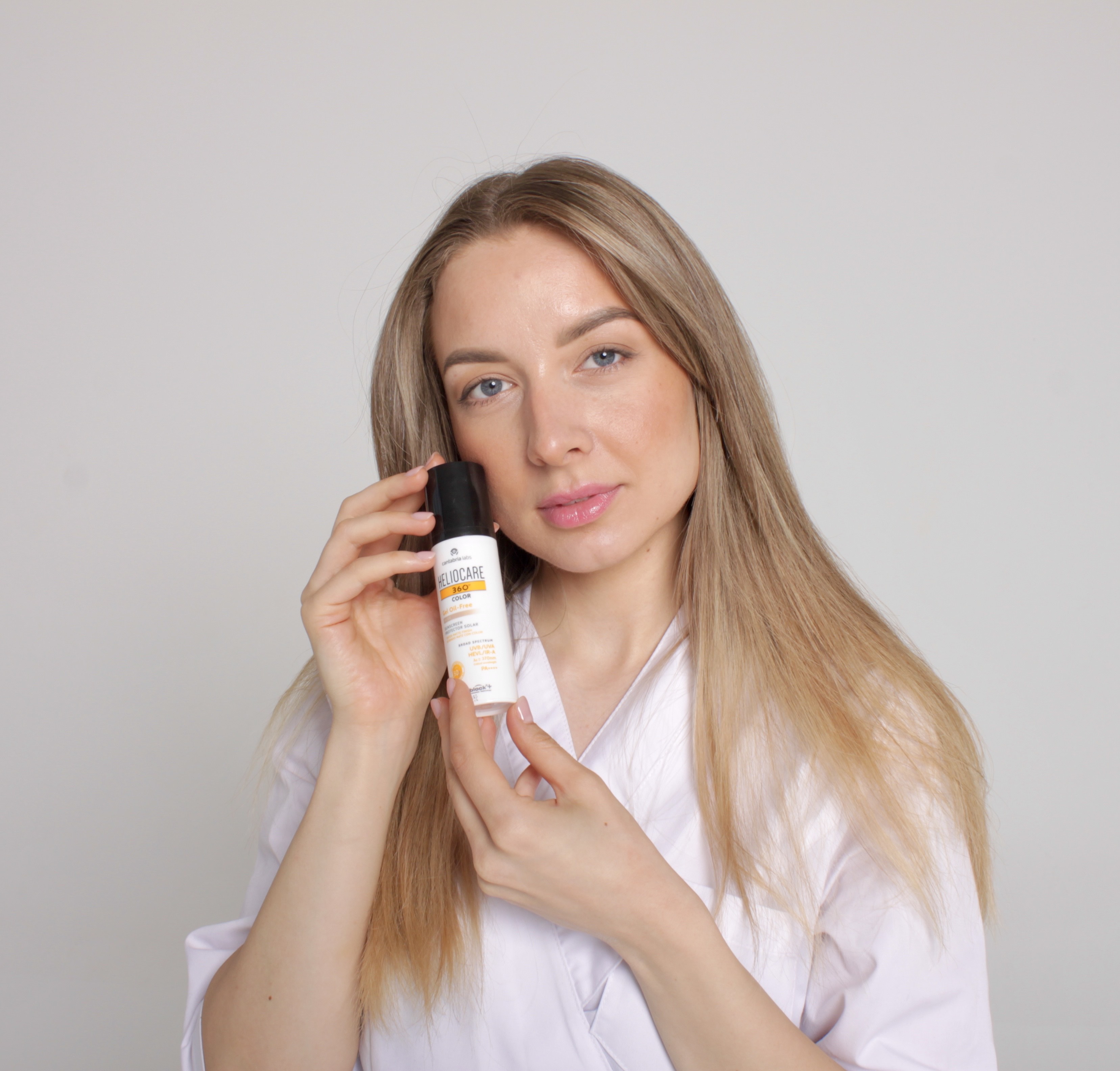 Kosmetologė Gintarė laiko rankose HELIOCARE SPF kremą