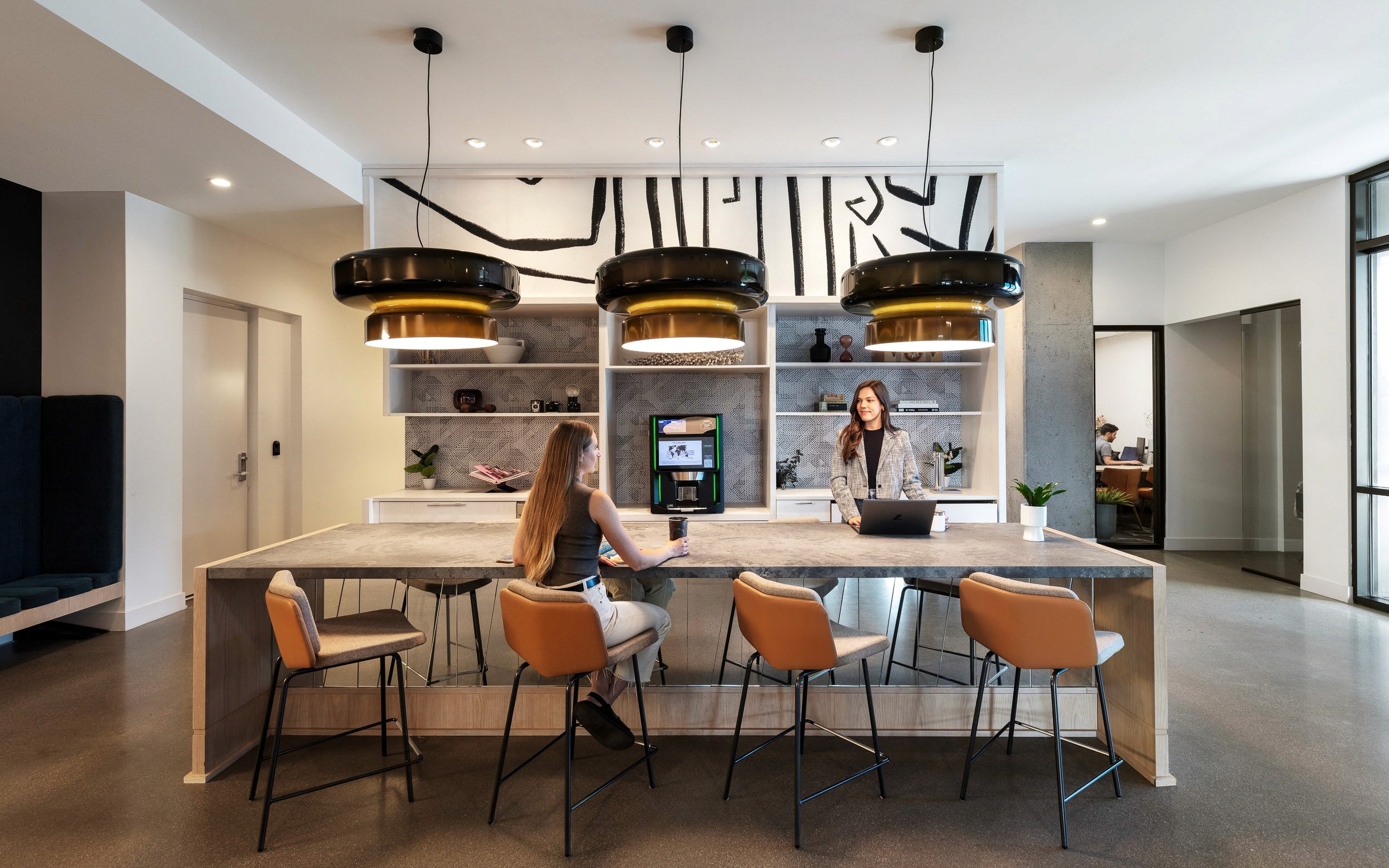 Modern kitchen island with chairs and pendant lights.