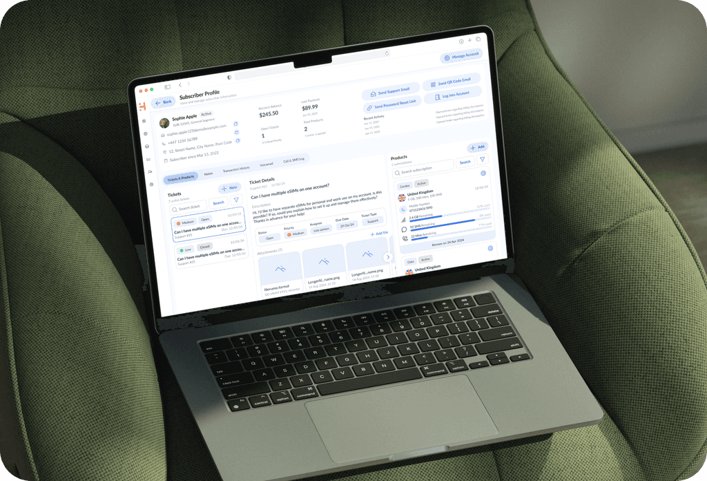 “Laptop displaying the redesigned HERO CRM subscriber profile interface, shown on a green armchair.