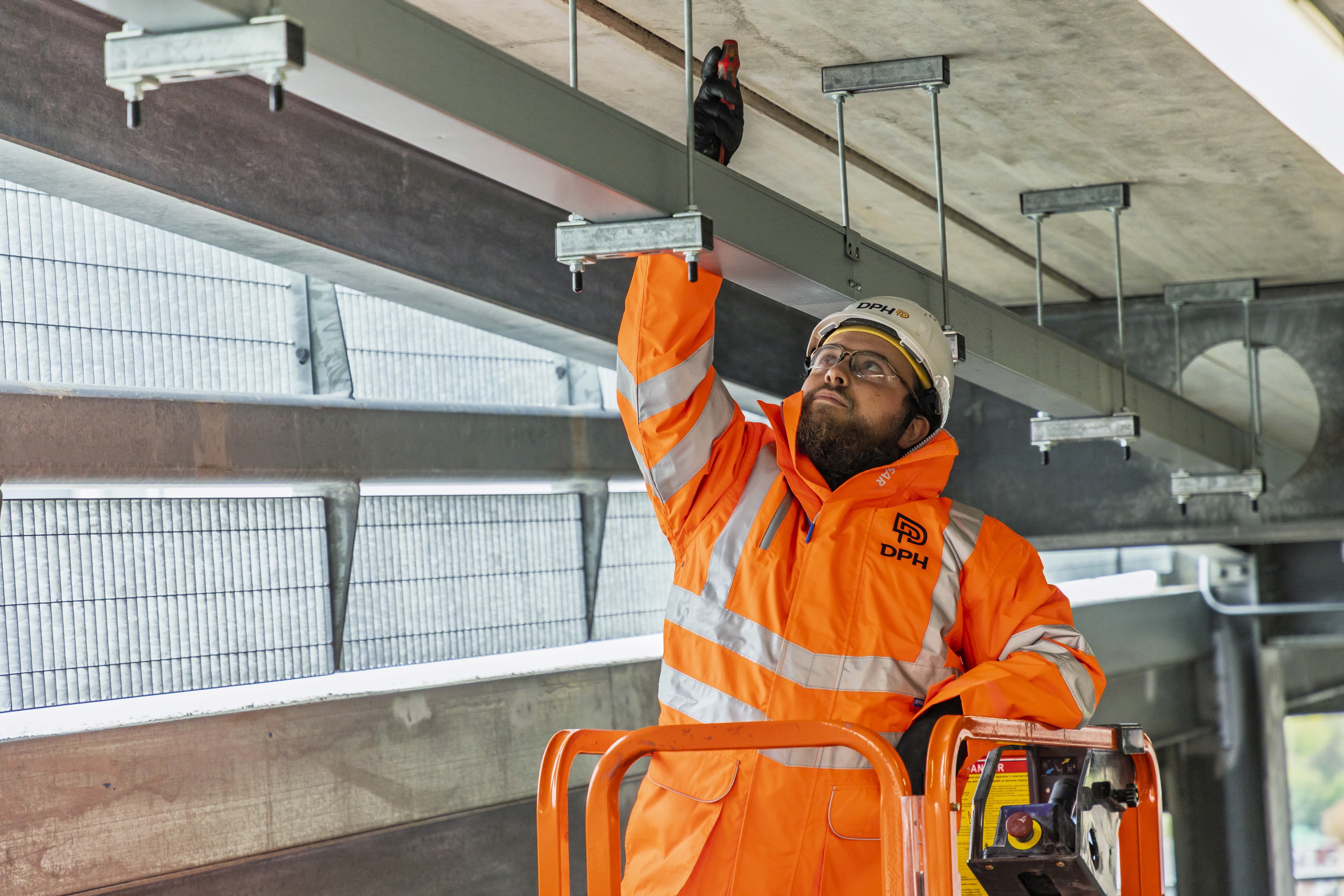 Entrance of a modern glass building with illuminated facade and reflections
