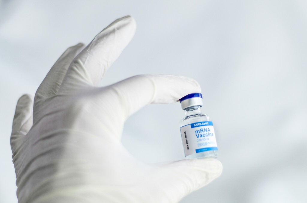 Hand of a person holding a bottle of Covid-19 Vaccine