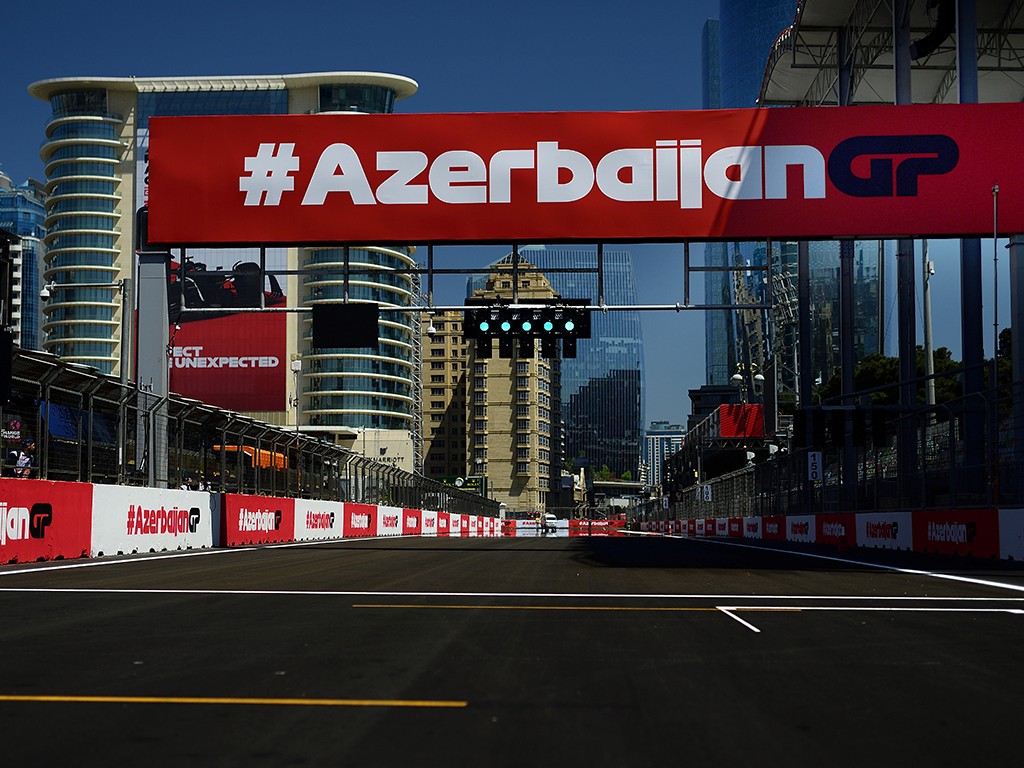 A close-up of a person wearing green-tinted glasses, with a serious expression and smooth skin.
