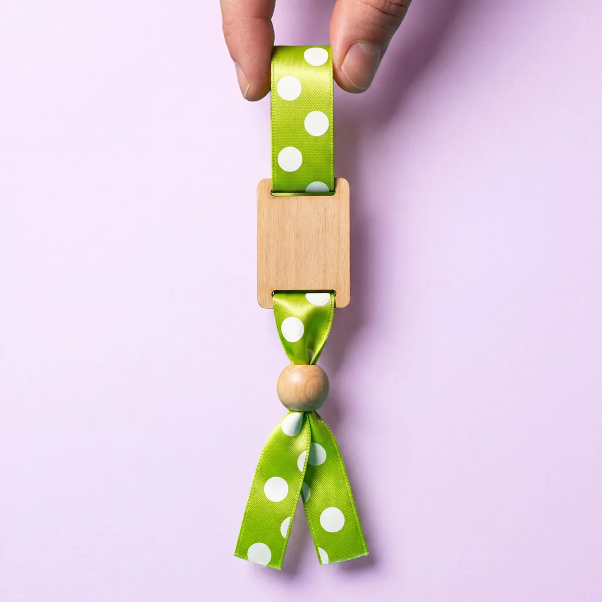 Fabric wristband with customisable wooden plate and knot closure