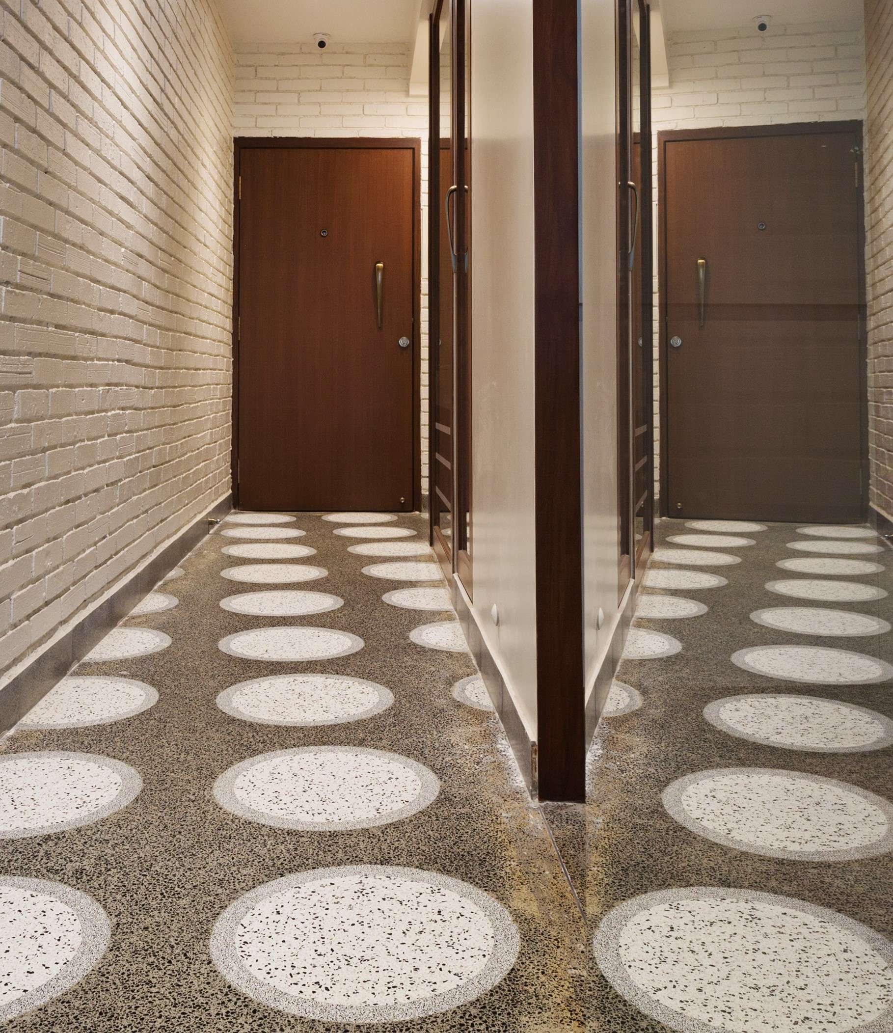 Nature-inspired preschool entrance with sculptural tree partitions and suspended green leaf ceiling panels.
