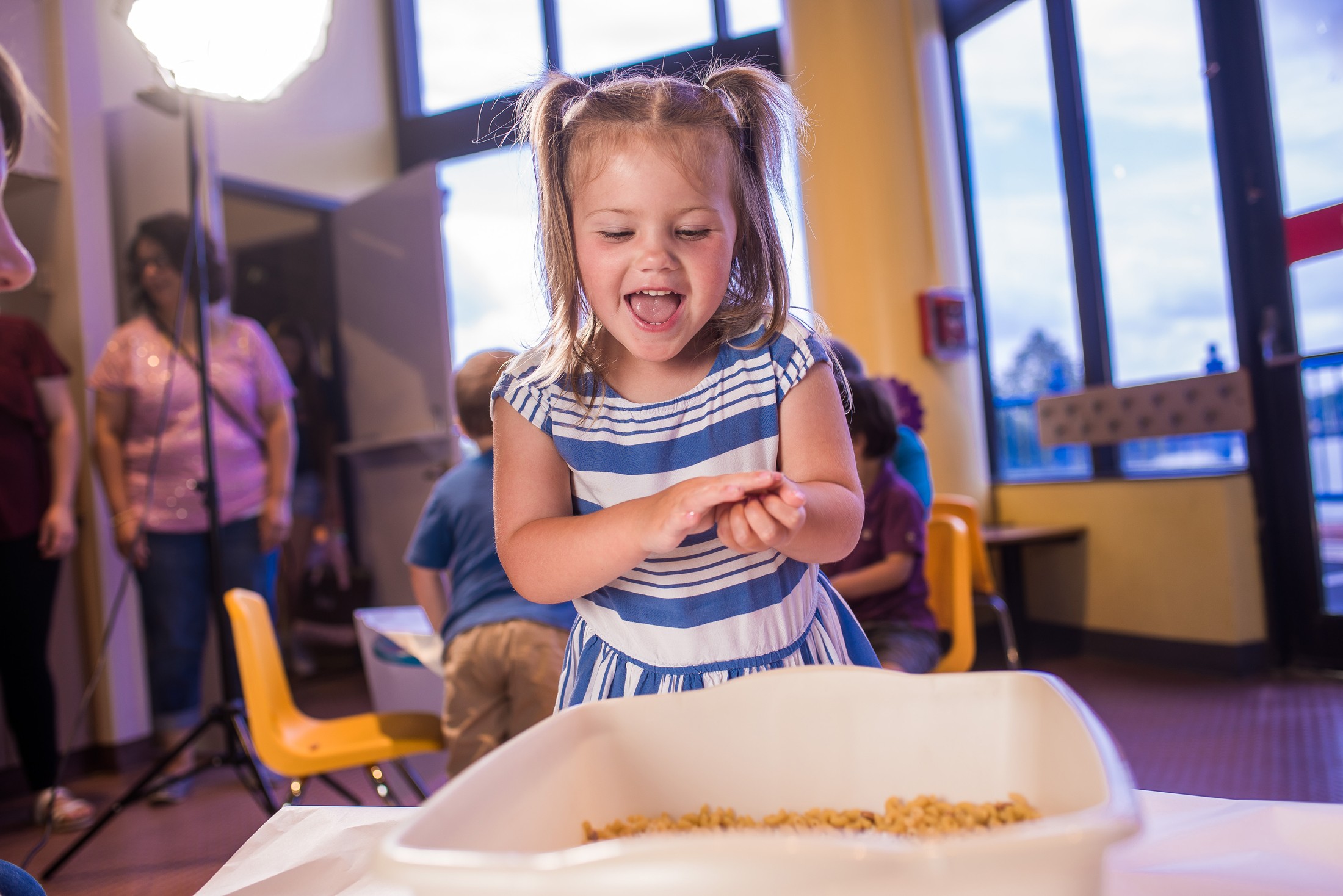 Young girl stands with an excited face.