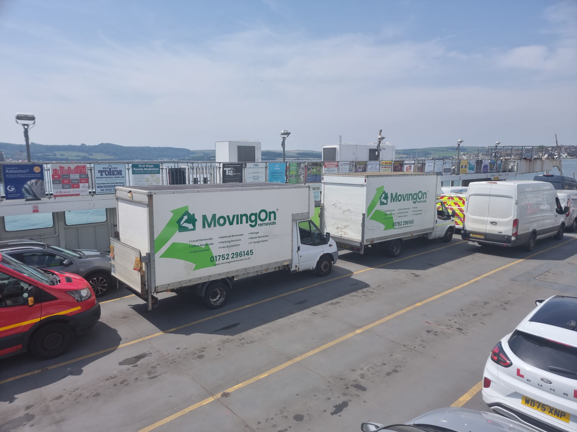 Two branded Moving On Removals vans parked on the Torpoint Ferry deck during a long-distance relocation from Cornwall.