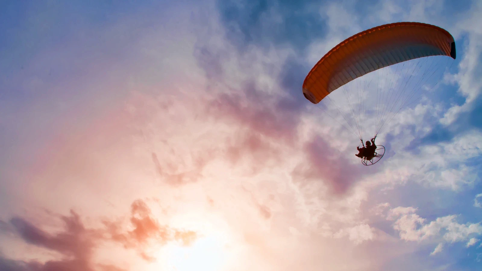 Paraglider in the air during a sunset.