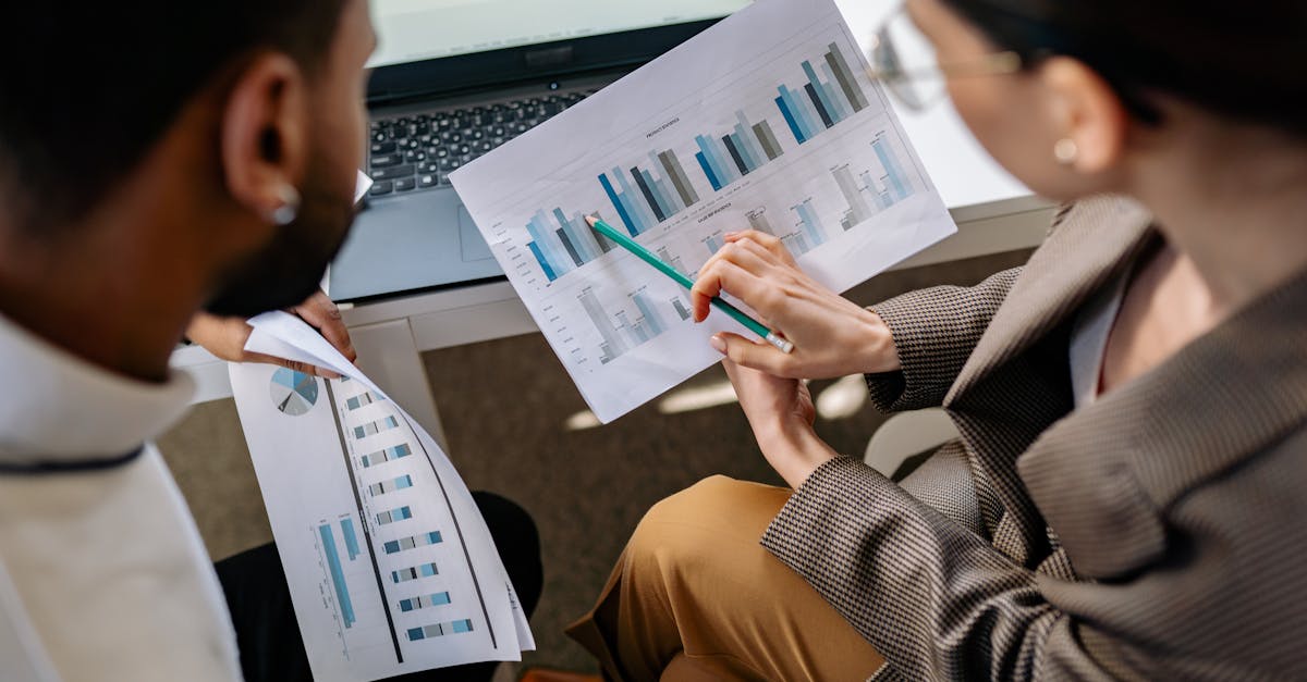Colleagues collaborating on data charts and discussing business strategies in an office setting.