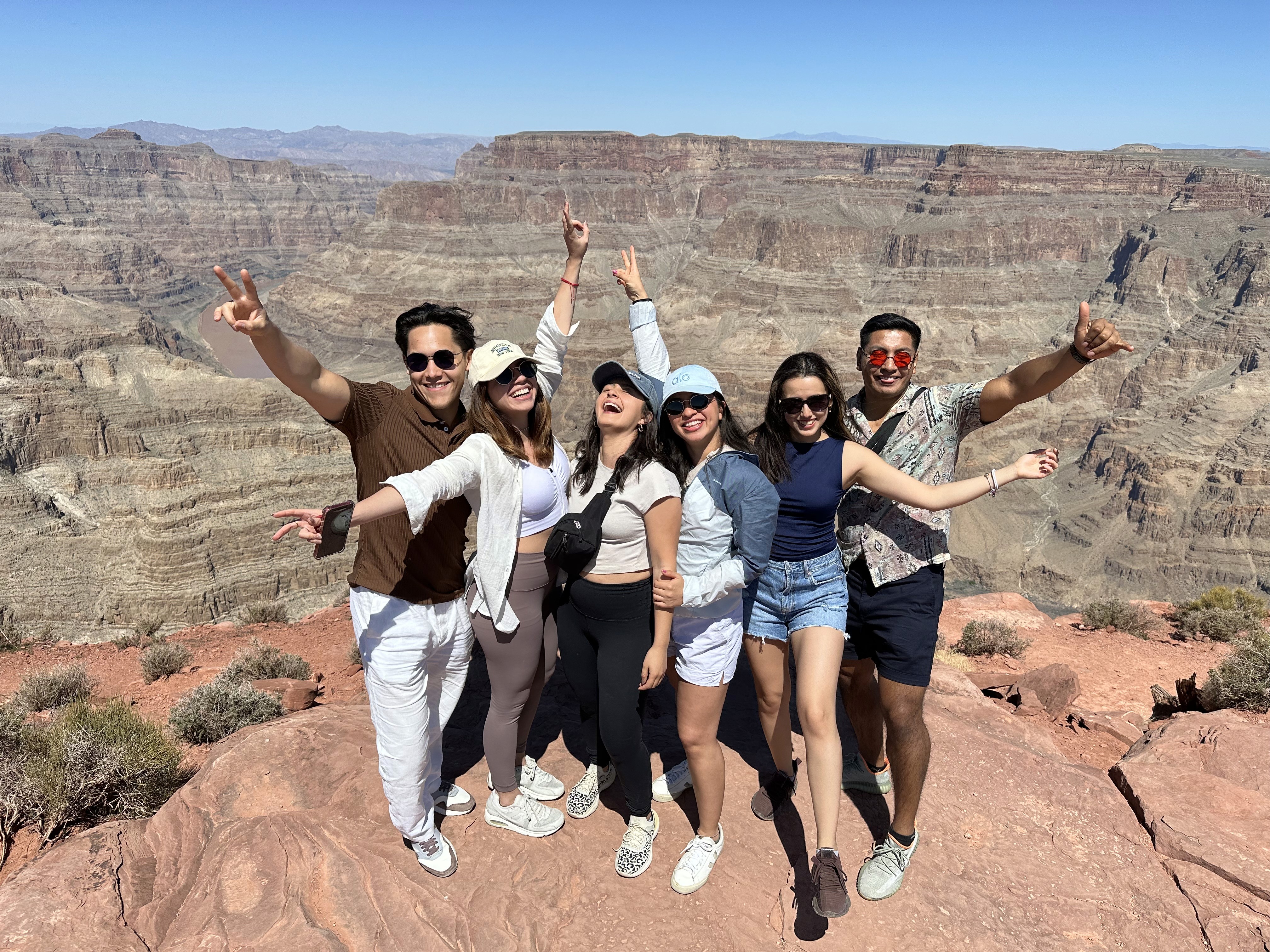 grupo de viajeros posando emocionados en el gran cañon de arizona