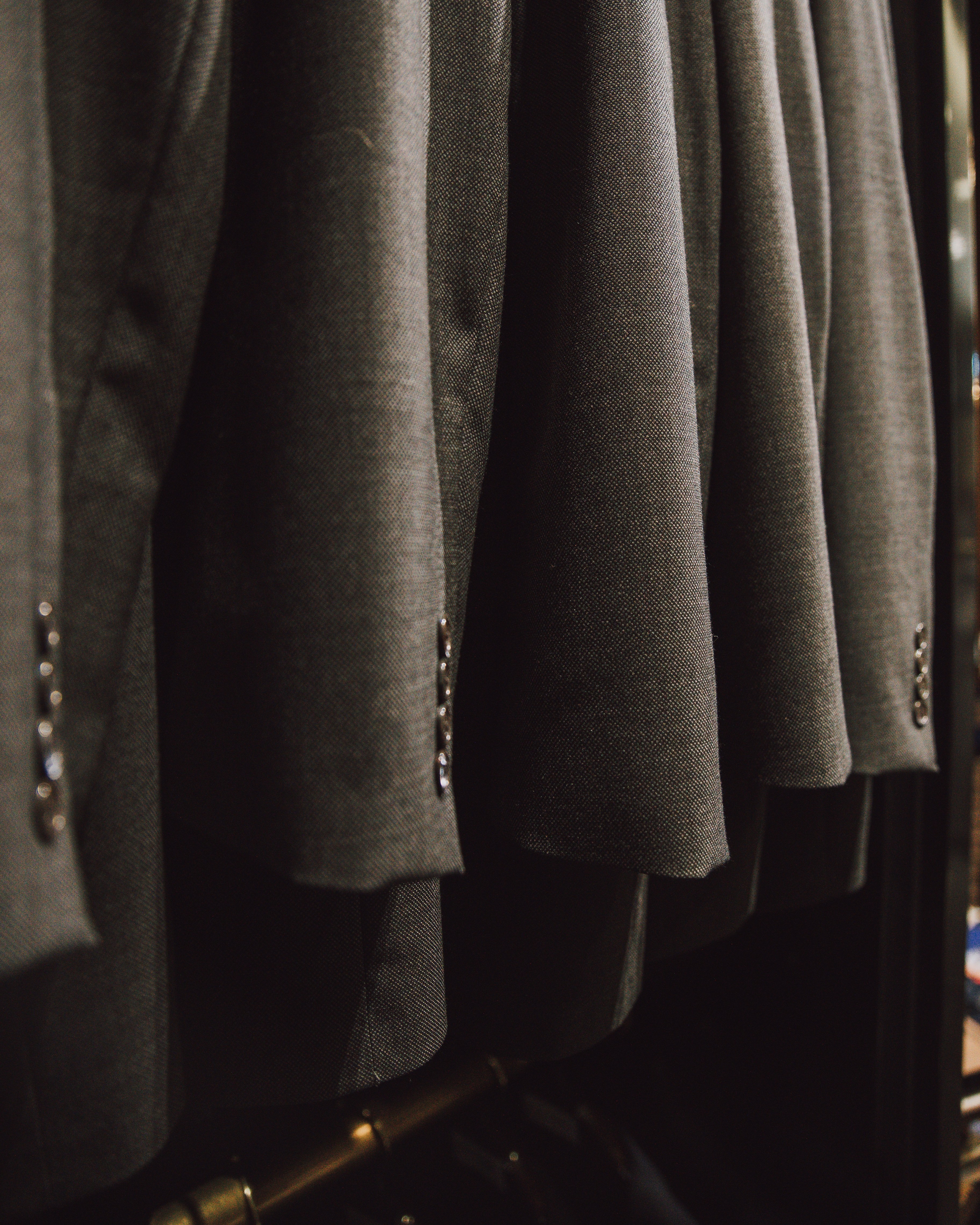 a bunch of suits hanging on a rack