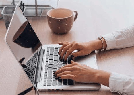 Writing on a laptop.