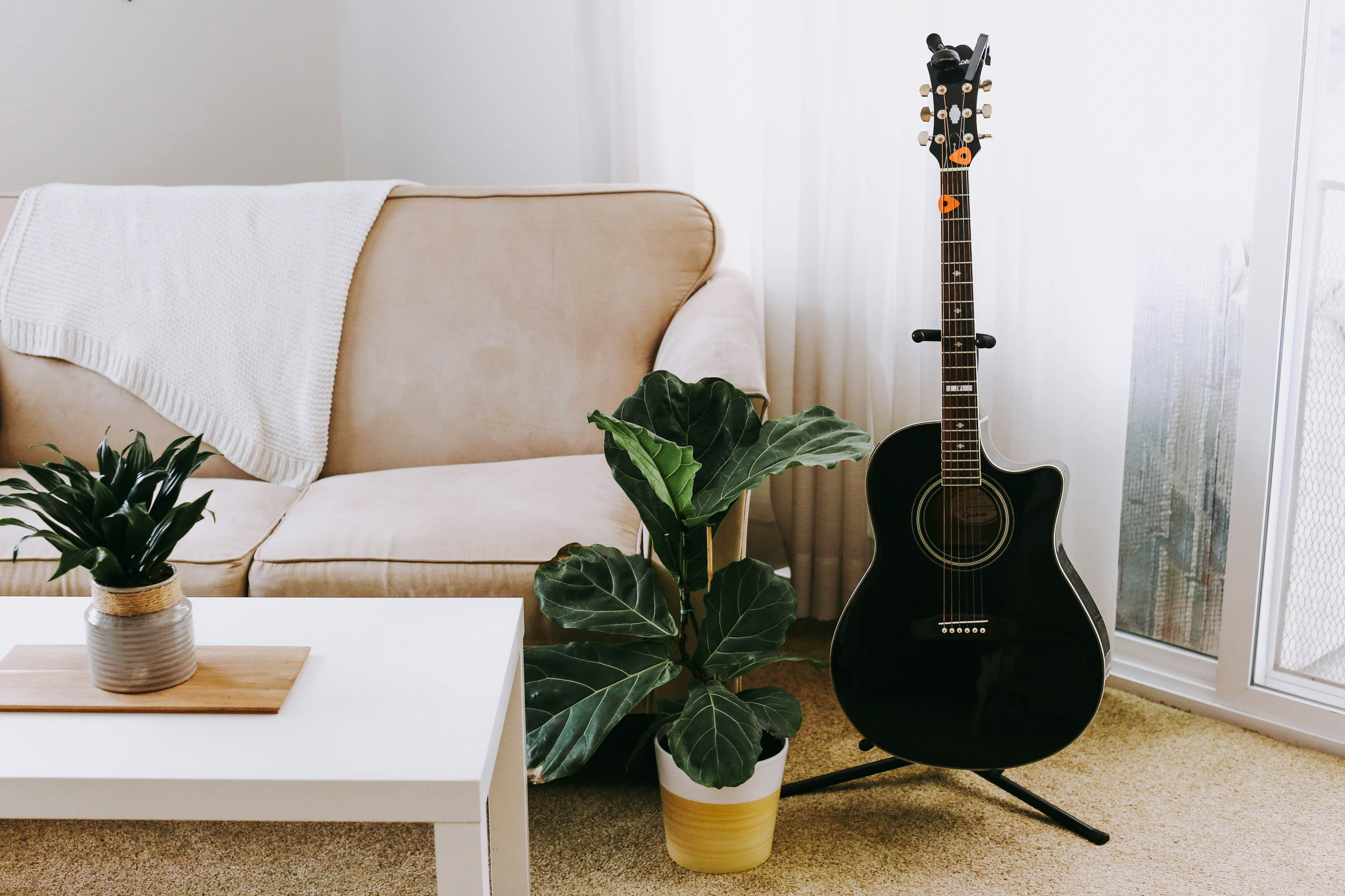 Guitar on a stand next to the couch