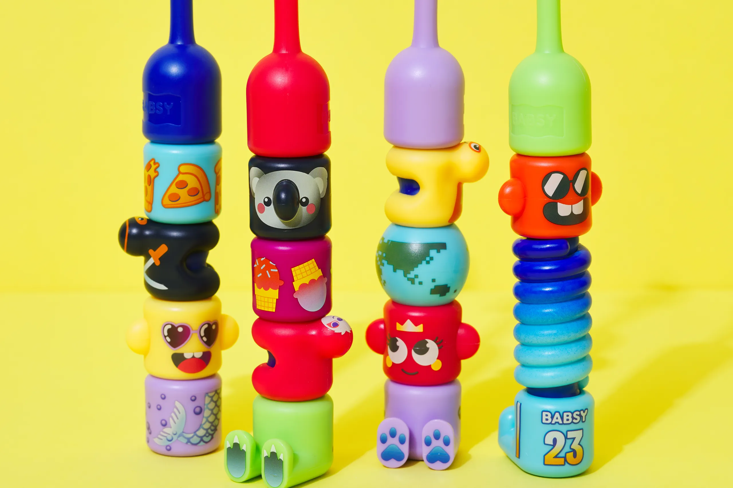 Four BABSY toothbrushes showing different stacked character-piece combinations