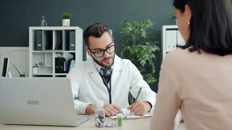 Doctor writing notes during a consultation
